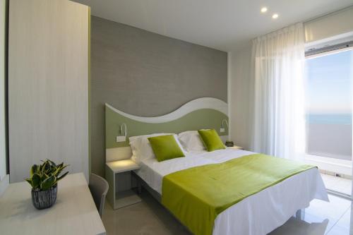 a bedroom with a large bed with a green headboard at Residence Flow-R in Riccione