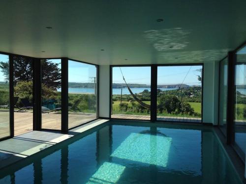 - une piscine dans une maison avec fenêtres dans l'établissement Pura Vida Camaret - Villa Vue Mer - sauna piscine intérieure, à Camaret-sur-Mer