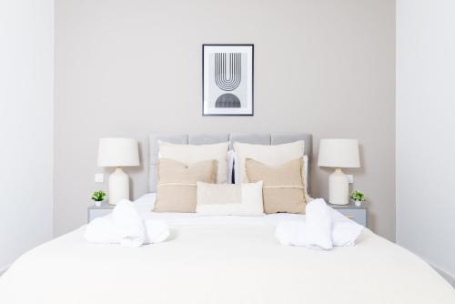 a white bedroom with a large white bed with white pillows at Appartement Luxueux à Draria in Draria