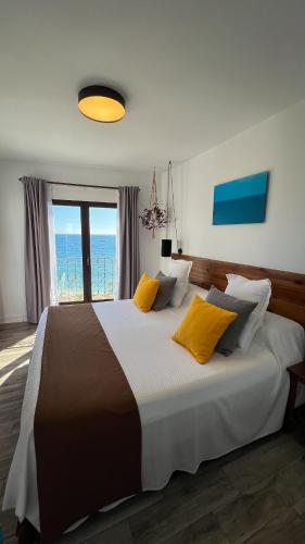a bedroom with a large bed with a view of the ocean at Hostal Boutique Casa del Mar Altea in Altea