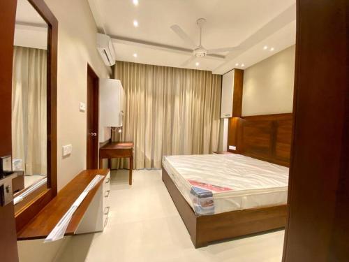 a bedroom with a bed and a desk in it at The Breeze- Urban Chic Apartment in Moratuwa
