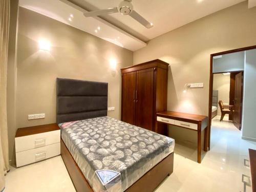 a bedroom with a bed and a dresser and a mirror at The Breeze- Urban Chic Apartment in Moratuwa