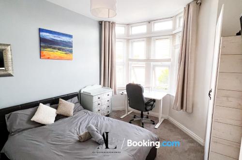 The Den 2 Bedroom Serviced Apartment By AltoLuxoExperience Short Lets & Serviced Accommodation With Free Wifi في بريستول: غرفة نوم بسرير ومكتب وكرسي