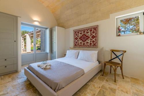 a bedroom with a bed and a chair and a window at Tenuta Palù By Raro Villas in Carovigno