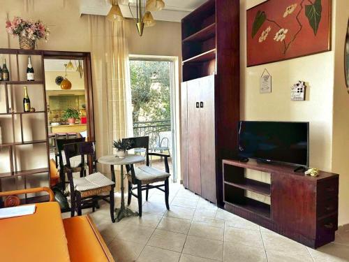 a living room with a television and a table and chairs at Vefa's Apartment- Nei Pori in Nei Poroi