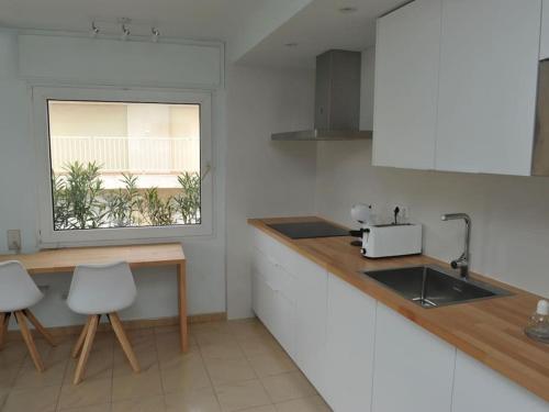 eine Küche mit Theke und Spüle und einem Fenster in der Unterkunft Apto a 1 minuto de la Playa en Sant Antoni in Sant Antoni de Calonge