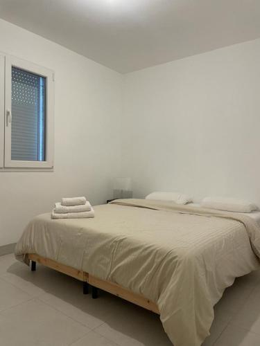 Un dormitorio blanco con una cama grande con toallas. en Villa Lancrans en Lancrans