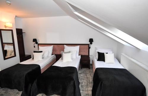a room with two beds with black and white pillows at Hotel Focus Centrum Konferencyjne in Lublin