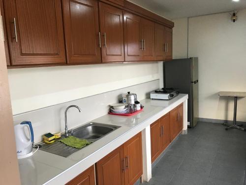 a kitchen with a sink and a refrigerator at Drew Hostel in Tagbilaran City