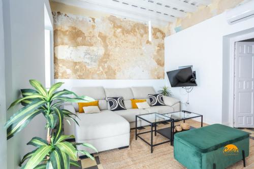 ein Wohnzimmer mit einem Sofa und einem Tisch in der Unterkunft La Casa del Alfarero by Cadiz Time in Cádiz