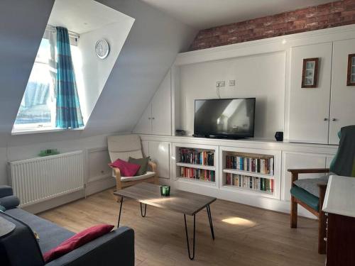 a living room with a couch and a tv at Modern Centrally Located Flat in Hastings