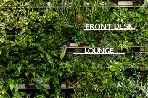 a wall full of green plants with signs on it at Tokyu Stay Aoyama Premier in Tokyo