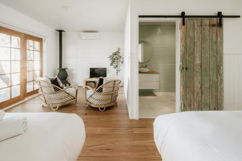 a bedroom with two chairs and a living room at Sur Mer Studio - Seaside Escape in Dunsborough