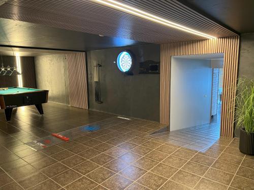 a room with a pool table and a clock on the wall at Hotel Natur Akureyri in Akureyri