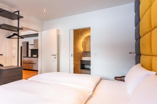 a bedroom with white walls and two beds at lechner living apartments in Wald im Pinzgau