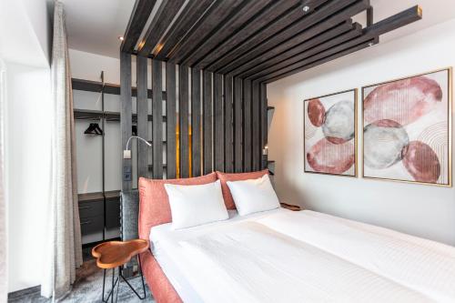 a bedroom with a large bed and a chair at lechner living apartments in Wald im Pinzgau