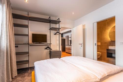 a bedroom with a large bed and a television at lechner living apartments in Wald im Pinzgau