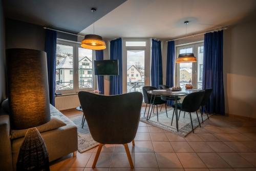 ein Wohnzimmer mit einem Tisch, Stühlen und einem Sofa in der Unterkunft BSW Ferienwohnungen Rügen in Baabe