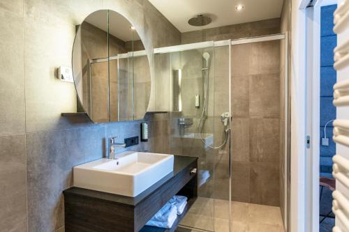 a bathroom with a sink and a shower at lechner living apartments in Wald im Pinzgau