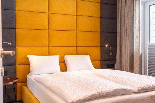a bedroom with a bed with two white pillows at lechner living apartments in Wald im Pinzgau