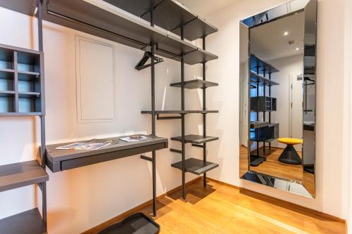 a room with black shelves and a mirror at lechner living apartments in Wald im Pinzgau
