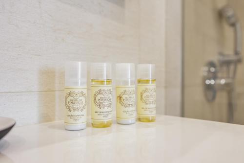 drei Flaschen ätherischer Öle auf einer Theke in der Unterkunft Terraços de Quarteira II Frolic by Real Properties in Cavacos