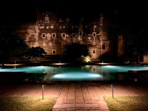 a castle at night with a pool in front of it at DEEPPURA GARH in Sīkar