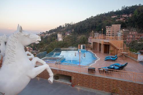 a white horse statue on top of a building with a pool at Hotel Sarathi in Dhulikhel