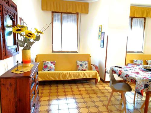een woonkamer met een gele bank en een tafel bij PERLA MARINA in Gallipoli