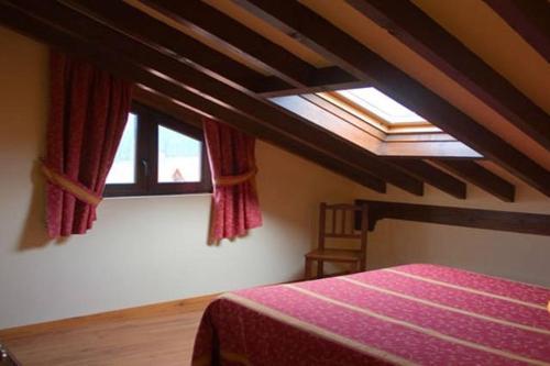 1 dormitorio con cama y ventana en Apartamentos Villa de Potes, en Potes