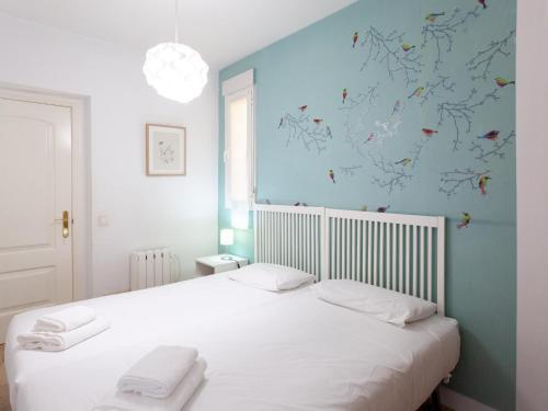 - une chambre avec un lit blanc et un mur bleu dans l'établissement Enorme y acogedor piso en la puerta del sol, à Madrid