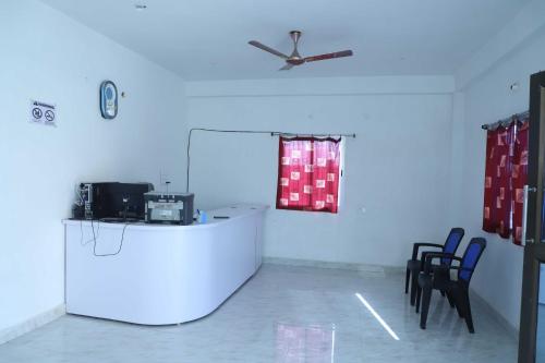 Zimmer mit Stühlen und einer Theke mit Fenster in der Unterkunft OYO Shiv guru guest house in Bodh Gaya