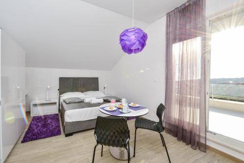 a bedroom with a bed and a table and a purple orb at Premium Villa Zečevo in Rogoznica
