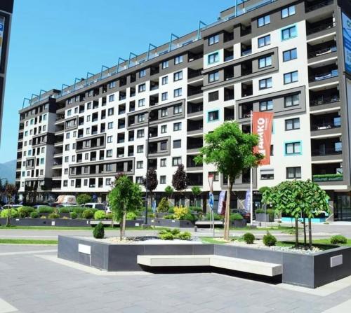 a large building with trees in front of it at Penthouse Apartman Bulevar Sarajevo in Sarajevo