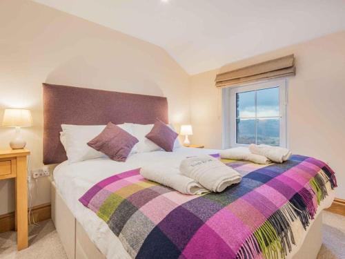 a bedroom with a large bed with a colorful blanket at 3 Bed in Dockray SZ247 in Dockray