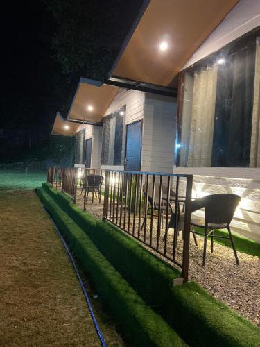 a house with a fence and chairs outside at night at The Bluewind Resort in Dehradun