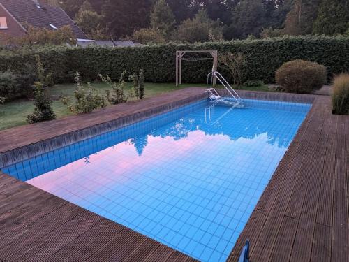 a blue swimming pool with a gazebo in a yard at Gemütliche Souterrain Wohnung in Lüneburg