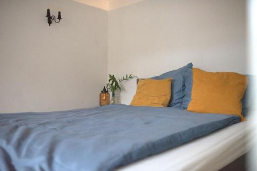 a bedroom with a blue bed with yellow pillows at Gemütliche Souterrain Wohnung in Lüneburg