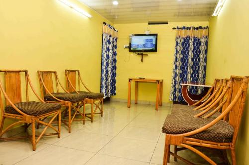 a waiting room with chairs and a flat screen tv at Munnar Valley View in Munnar
