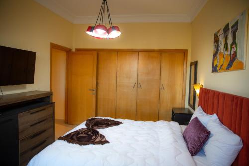 a bedroom with a white bed and a television at ROYAL GOLF DE FES in Fez