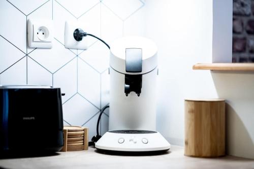 un appareil blanc posé sur un comptoir dans une pièce dans l'établissement Maison de Brique- CINEMA ROOM-BABY-FOOT - 10min à pieds Gare RER A- TRÈS PROCHE ARENA LA DEFENSE ET PARIS, à Houilles