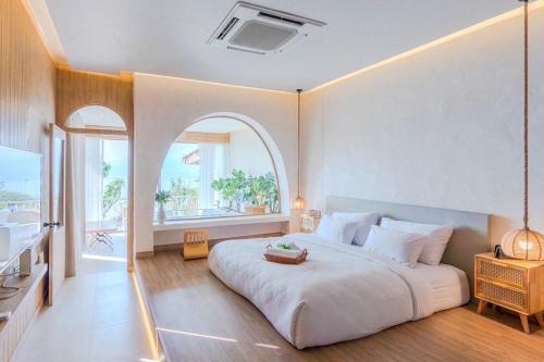 - une chambre avec un grand lit blanc et une voûte dans l'établissement Le La Lake Resort and Spa, à Kaeng Krachan
