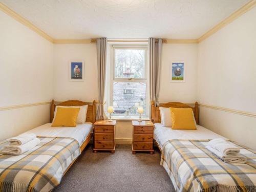 2 camas individuais num quarto com uma janela em 2 Bed in Eskdale SZ464 em Beckfoot