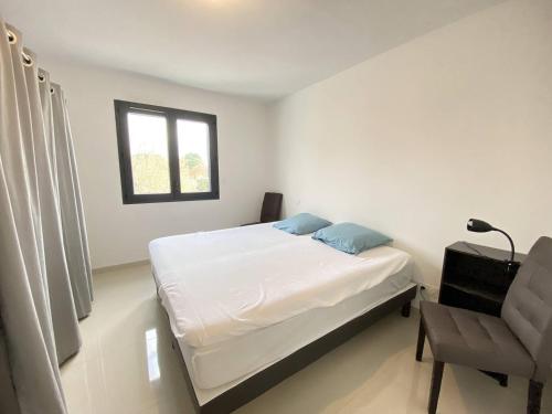 une chambre avec un lit, une chaise et une fenêtre dans l'établissement T2 avec terrasse et parking, à Narbonne-Plage