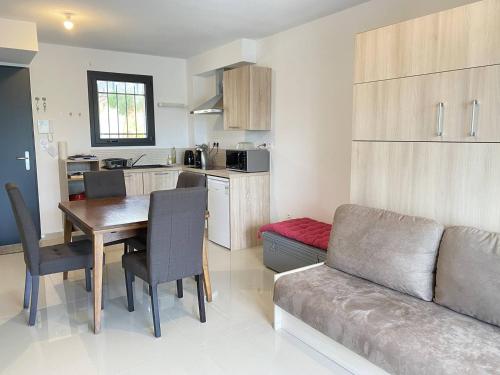 une cuisine et un salon avec une table et un canapé dans l'établissement T2 avec terrasse et parking, à Narbonne-Plage