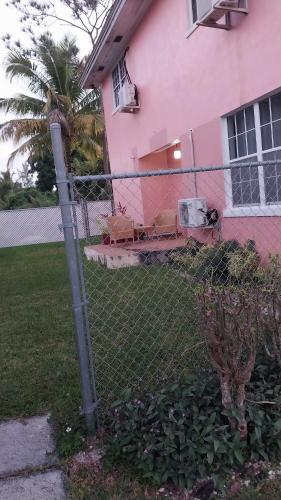 a fence in front of a pink house at Ann's Inn in Nassau