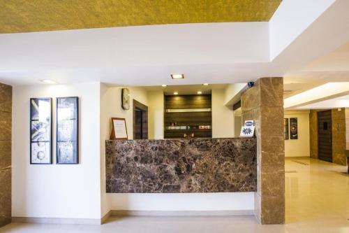 a lobby of a building with a stone wall at Reeva Regency in Shirdi