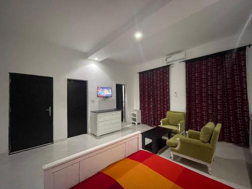 a living room with a tv and two chairs at WHITE FLAT ALMADIES in Dakar
