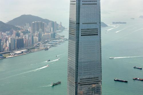 a tall building next to a body of water at The Ritz-Carlton, Hong Kong in Hong Kong