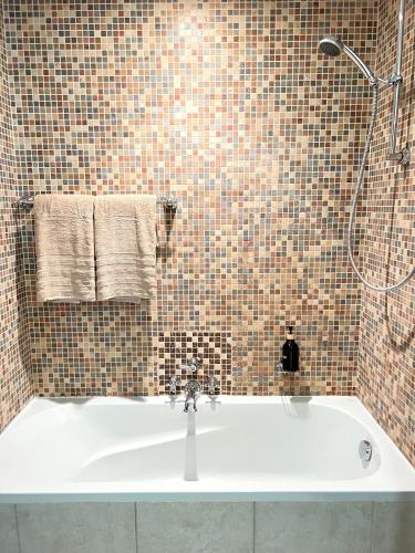a white bath tub in a bathroom with a shower at SmartApt Elegant 1 BDR Burj view in Dubai